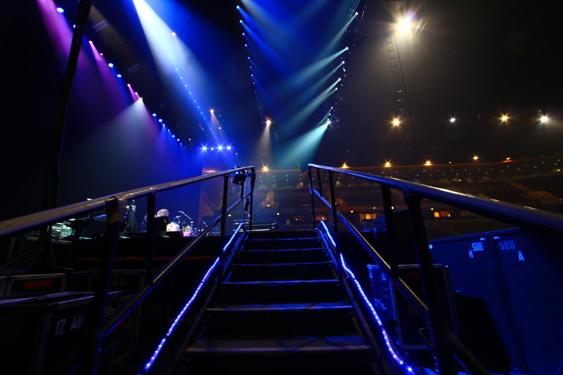 A stage access ramp and stairway leading up toward the lit stage